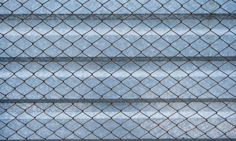 Old aluminum galvanized background covered with wire mesh grille. Metal texture